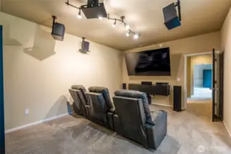 Down the hall, discover an additional bonus room, currently configured as a home theater and office. The home theater setup—including chairs, speakers, and TV—is negotiable with the sale, offering a turnkey entertainment option.