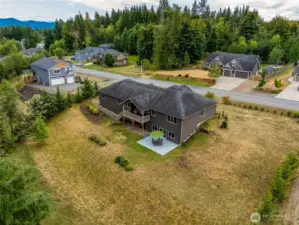 The backyard extends deep into the trees, offering opportunities to expand usable yard space for a firepit, play area, or lush lawn, ensuring both beauty and functionality.