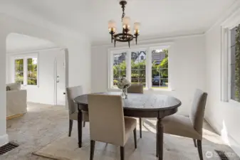 Formal dining room with vintage light fixture, leading glass windows, coved ceilings and picture rail.