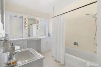Large main level full bath with original tile floors and built in vanity