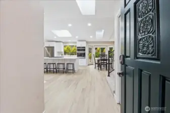 Bright and welcoming entry opens to airy living spaces, skylights, and a beautifully updated kitchen.