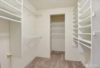 Spacious walk-in closet with built-in shelving, hanging space, and room for easy organization.