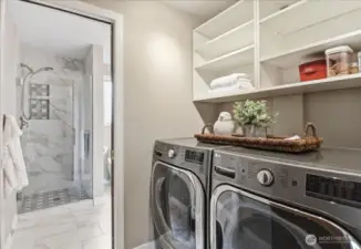 Convenient lower-level laundry area with built-in shelving and easy access to the adjacent 3/4 bath.