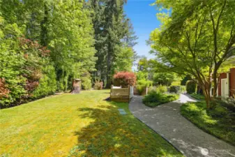 This property has multiple garden beds and is layered with mature plantings like dogwoods, hydrangeas, peonies, tulips and roses.