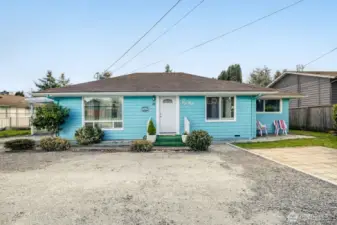 Charming turquoise single-story home in Everett, WA with spacious gravel parking area and inviting curb appeal.