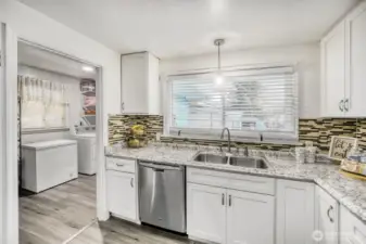 Functional kitchen layout with ample storage and convenient access to laundry area.