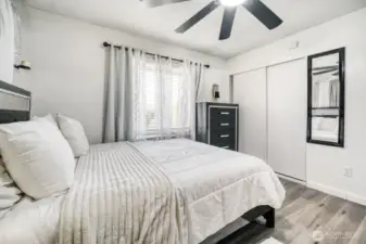 Bright main bedroom featuring large windows and clean contemporary finishes.
