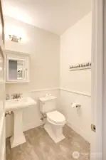 Guest and hot tubbers have access to this powder bath off the media room. Wainscotting helps keep things charming and durable.