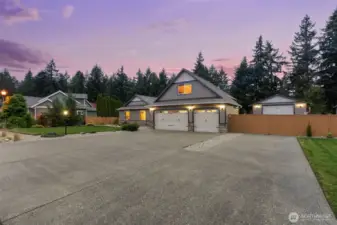 Large driveway with RV parking behind gate.