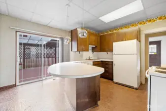 Kitchen with eat-in space and slider to covered deck.