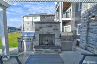 Community patio has natural gas fireplace, two gas grills, tables and chairs.