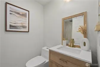 Remodeled primary bathroom with Bedrosian tile surround (tiled to ceiling), quartz countertop, LVP flooring and modern fixtures + mirror.