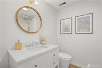 Remodeled hallway guest bathroom with Bedrosian tile surround (tiled to ceiling), soaking depth tub, quartz countertop, LVP flooring and modern fixtures + mirror.