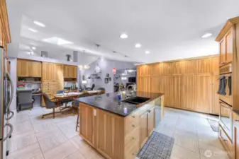 Tile floor, natural granite countertops, custom built solid wood cabinets. Sink on island.