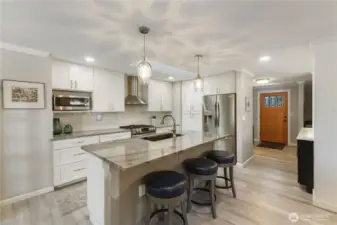 The 2-years new updated kitchen has custom cabinets, new appliances, a breakfast bar for those quick meals, pendent AND can lighting