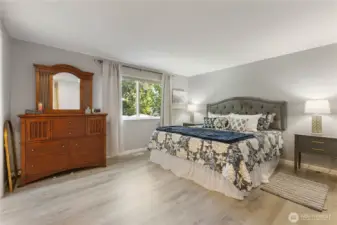 Spacious primary bedroom with natural light and a walk in closet