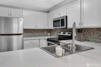 Beautiful countertops are complemented by a lovely mosaic backsplash.