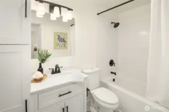 Brand new family bathroom shared by two secondary bedrooms. Shower curtain and rod are staging items.