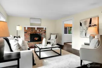The Living Room includes hardwood floors and a cozy, brick fireplace. And the framed opening leads to a pretty Dining Room.