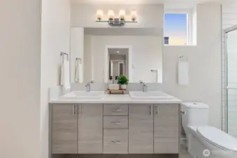 Primary Ensuite Bathroom includes dual vanity + large walk in shower + custom storage shelving + natural light.