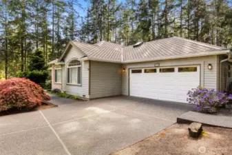 2 car garage and walkways to both sides of the home. Flowers and trees in bloom!