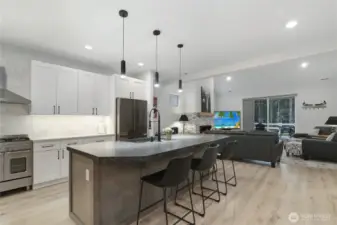 Gourmet kitchen with oversized leathered granite island open to great room