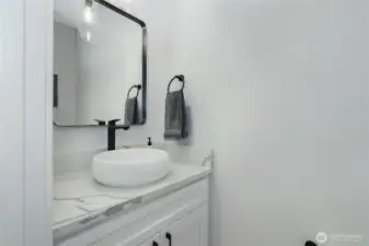 Powder room for guests is polished with custom accents