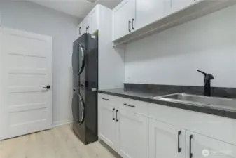 Laundry room with added storage, folding area, and sink - all appliances offered in sale