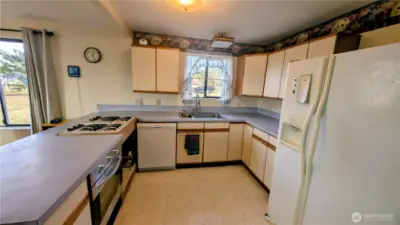 Kitchen features a propane cooktop and convection oven.