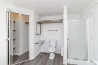 Primary bathroom stores hot water heater in hidden closet on left