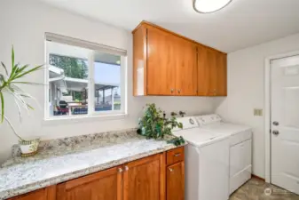 Located between the garage & the kitchen is the laundry room w/ nice folding countertop & cabinets.