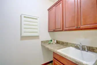 Laundry room with deep sink, great storage and convenient to the primary bedroom.