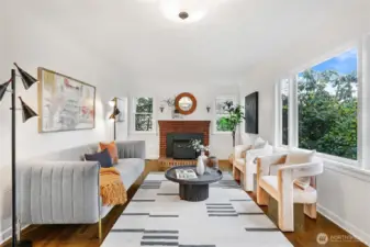 Refinished hardwoods in light-filled living room with fireplace/insert, coved ceiling and leaded glass windows.