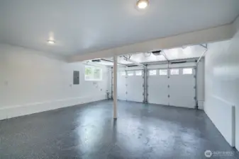 Polished and expansive garage with new automatic doors.