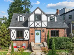 This storybook Tudor with classic architecture including timber frame, gable roof and brick exterior delightfully welcomes you home.