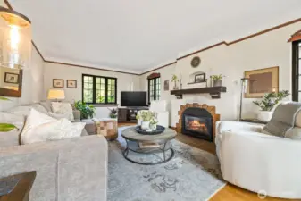 Welcome to this beautiful Tudor home with classic architectural finishes within this warm living room with designer paint, new gas fireplace and stunning Andersen windows.