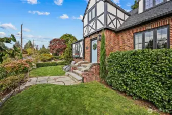 Stone pathways and established landscape highlight this quinnessential Tudor home.