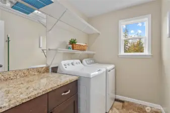 Room to work in this large laundry room with more granite countertops and storage