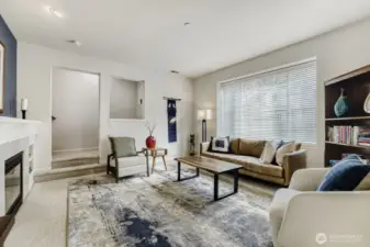 Another view of the living room with the large picture window and the entrance to the staircase to the upper floor.