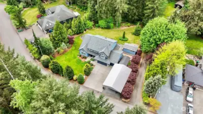 Aerial shot of the home shows the 22 x 38 covered parking. Plus 2 sheds 10x20 & 12X20. Beautiful established yard.