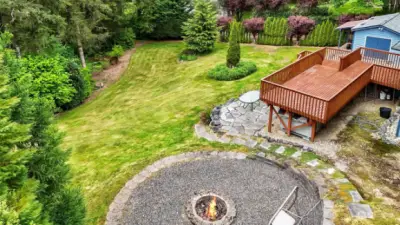 Aerial shot of large firepit plus a view of deck and backyard.
