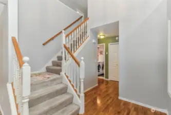 Beautiful staircase and gleaming hardwoods in the entry of home.