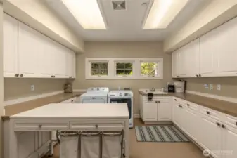 Large laundry room with plenty of cabinets and walk in closet.