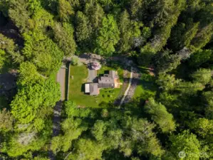 Nestled against woods on three sides, with a tall privacy fence along Kingston Street