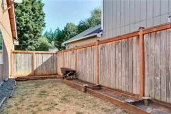 Side yard view, freshly landscaped, wheel barrow stays!