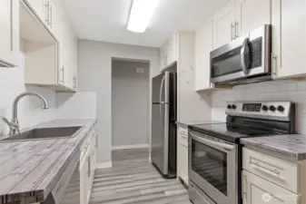 Updated kitchen has newer stainless appliances that stay with the home.