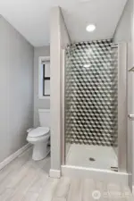 This bathroom also has lovely tile work on the walls and floors as well as a glass shower door.