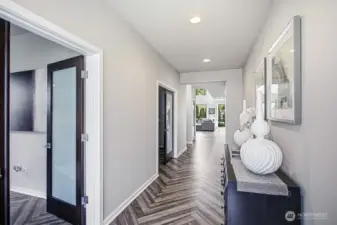 Clean lines and wide-plank herringbone flooring guide you toward the light-filled heart of the home.