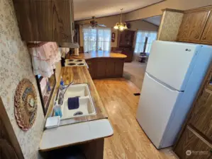 Thru the kitchen to the counter extension with bar stools and into the great room.