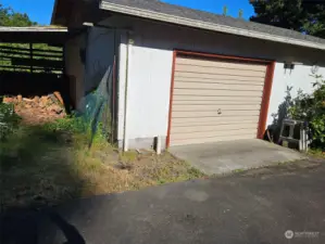 Covered area for wood storage next to the detached garage.